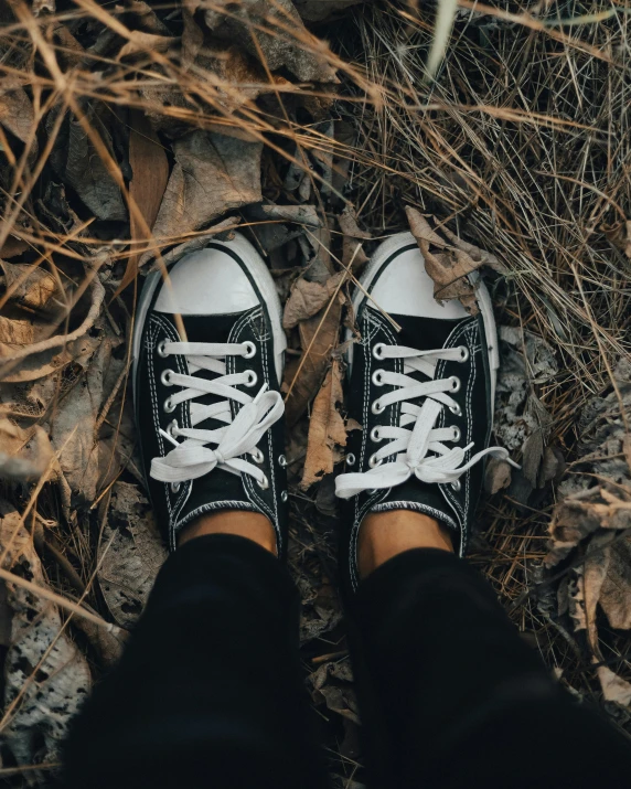 a person standing on the ground with black shoes