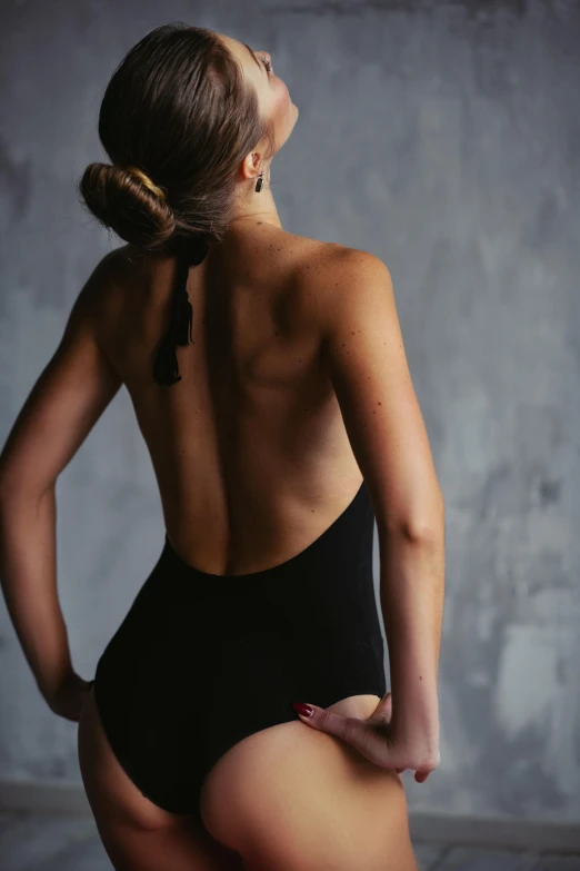 a woman in a black swimsuit is posing for the camera