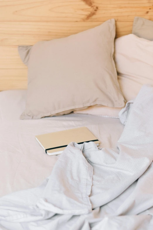 a book laying on top of an unmade bed