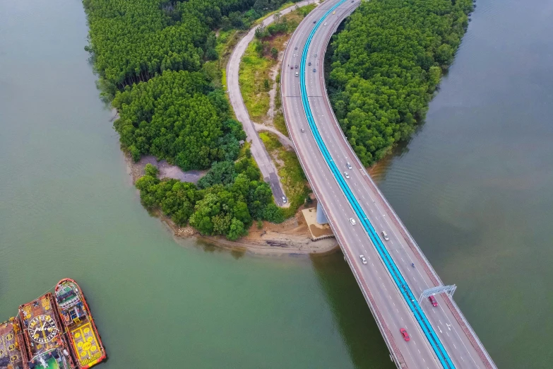 a long and narrow bridge on a river near a forest