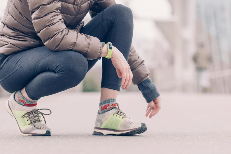 a woman crouched in her sneakers on the ground