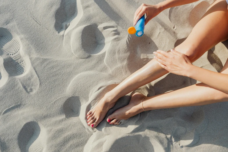 a woman wearing sandals sitting on a beach