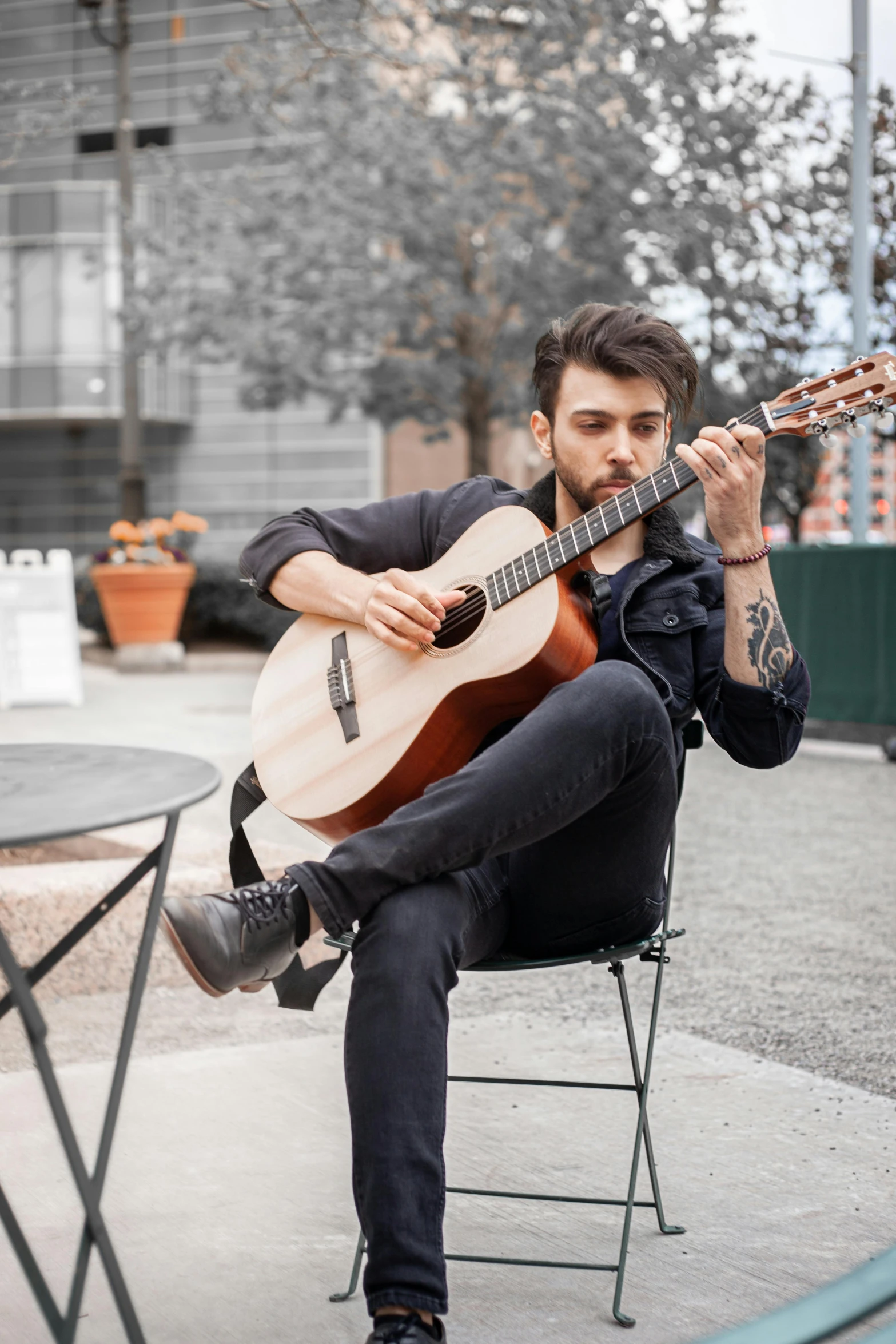 a man is playing an acoustic guitar on the chair