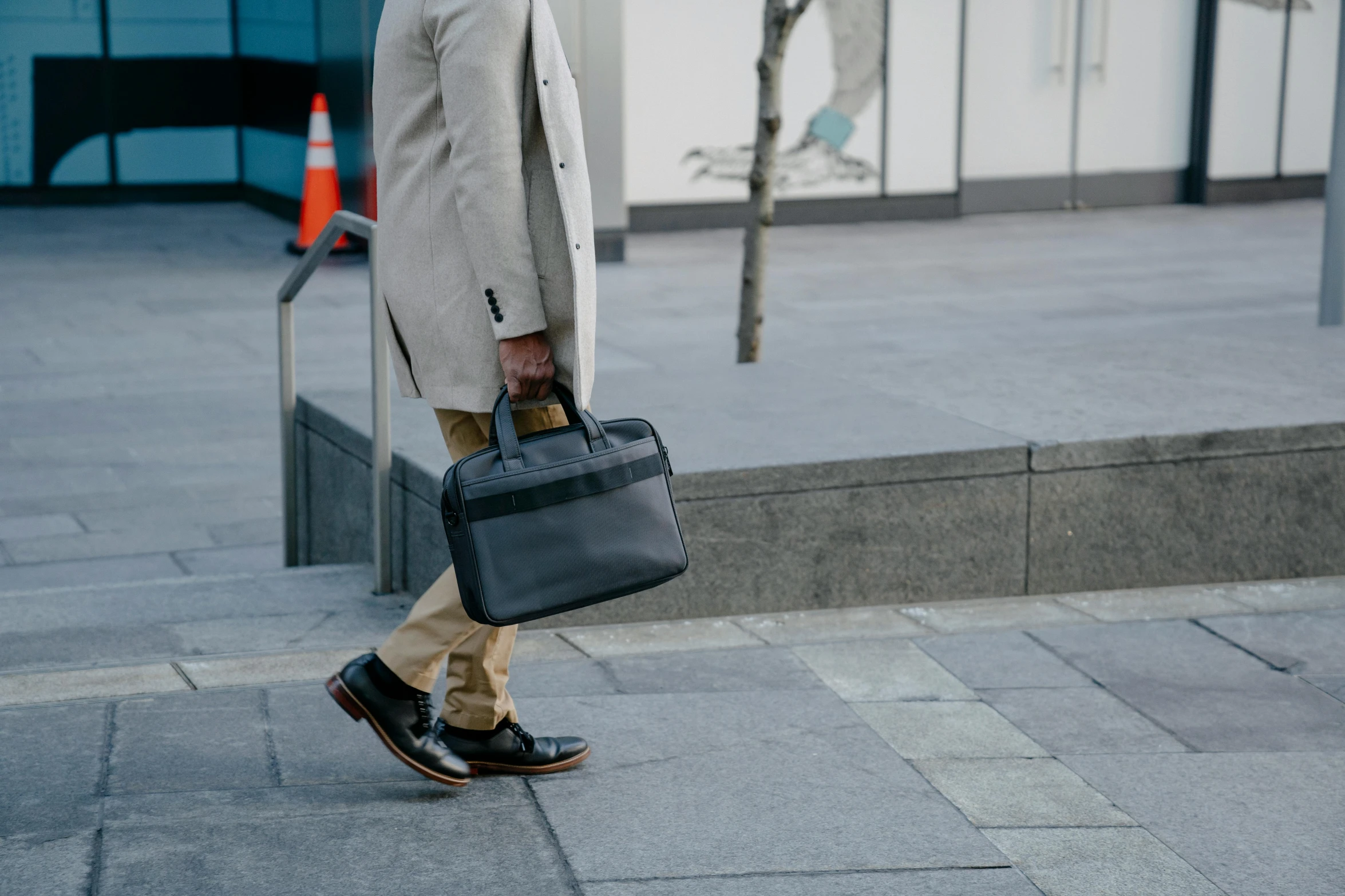 a man walks down the street carrying a briefcase