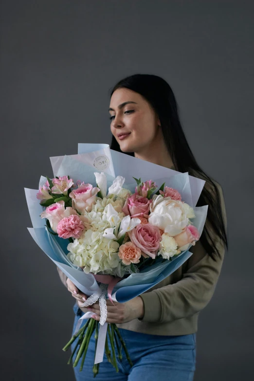 woman holding a bunch of white and pink flowers