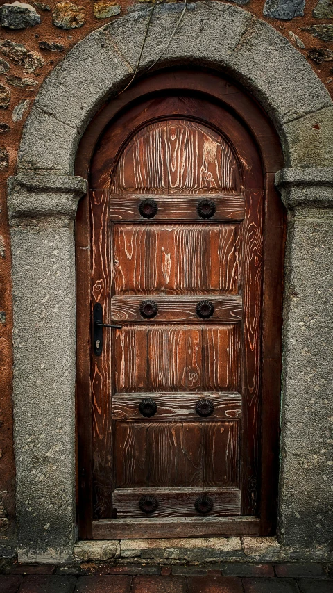an ornate wood door set into the side of a stone building