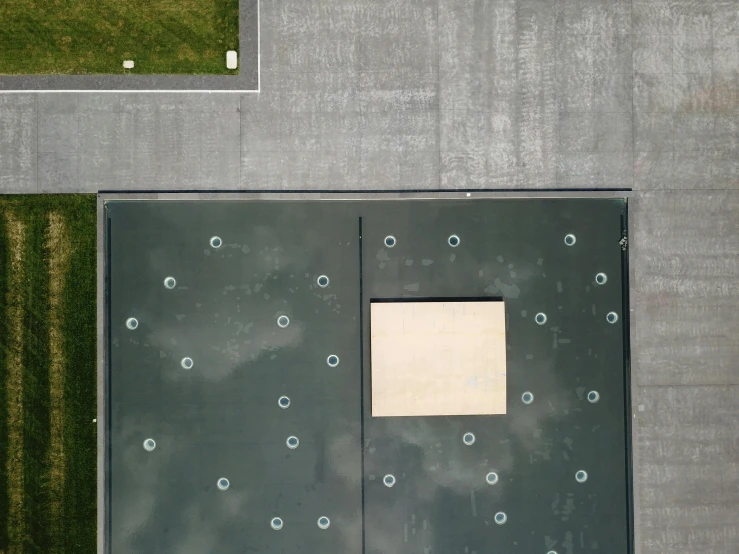 a po taken from a plane of a grass field and sidewalk with a door with the words, on which there is an image of an object