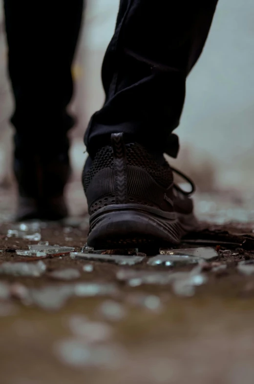 a black shoe on the ground in the rain