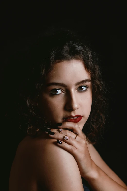 a woman in black with red lips and nails posing for the camera