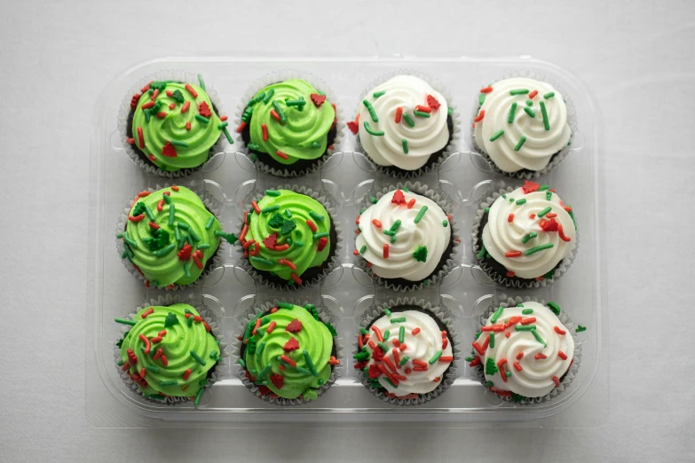 cupcakes with green frosting are in a tray