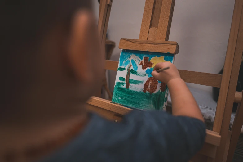 a man is drawing and painting a picture on an easel