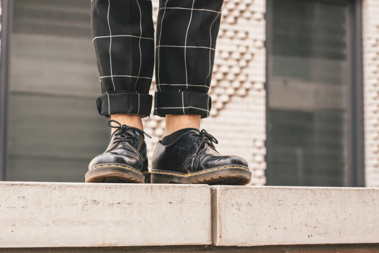 a person standing on a ledge with their feet propped up