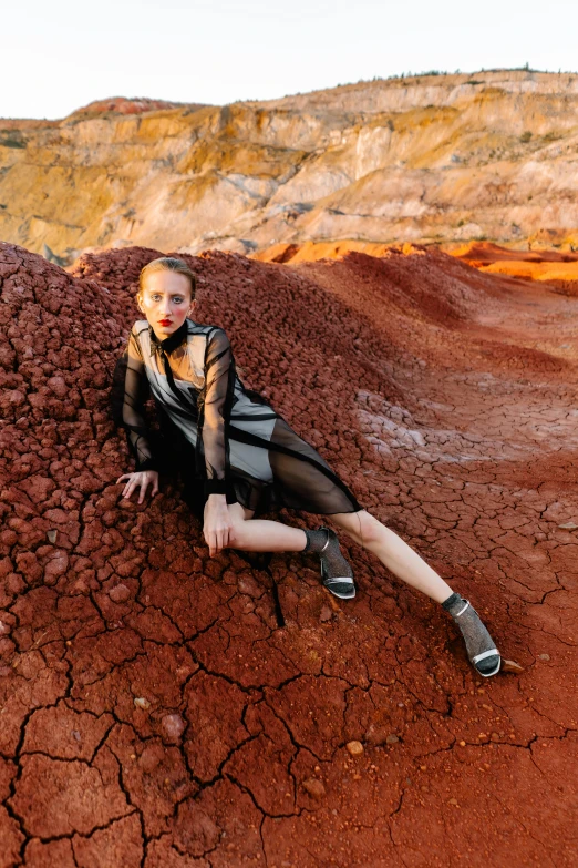 a girl in a black dress sits on the ground