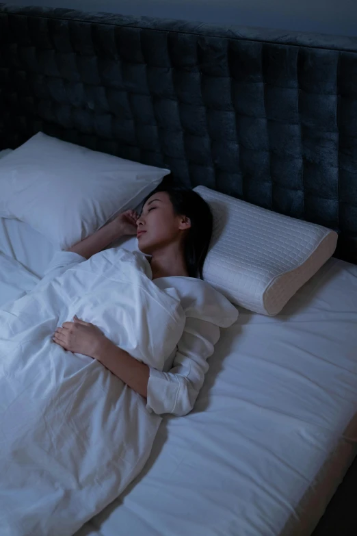 a woman is sleeping in bed with pillows