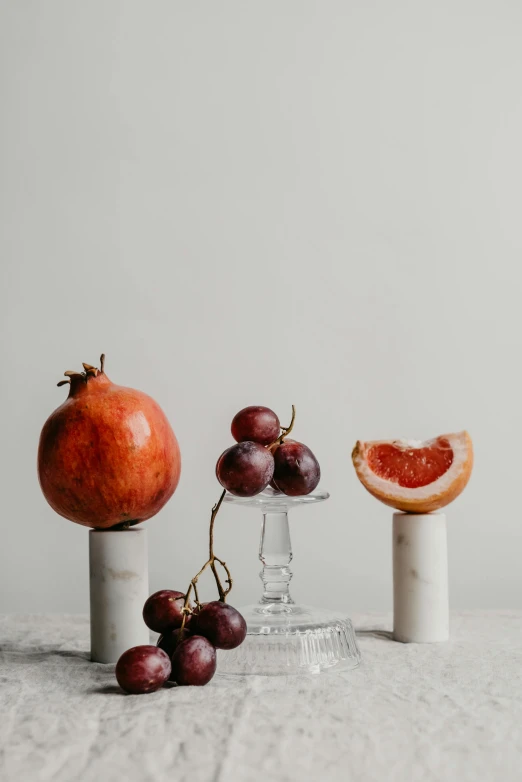 some fruit sitting on some white pedestals