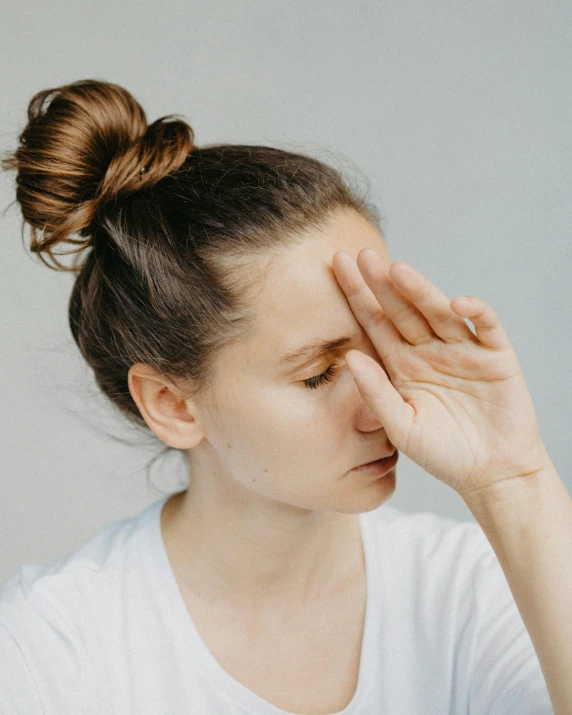 a close - up po of a woman touching her face