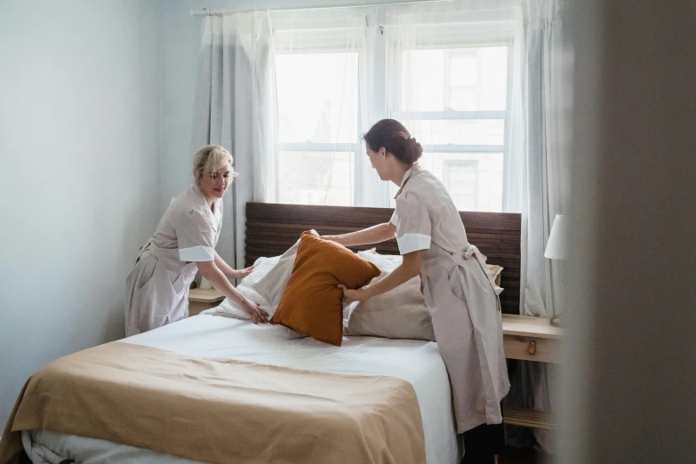 two women setting up a el bed in a room