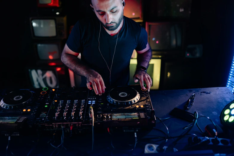 a dj mixes music at an event in the dark