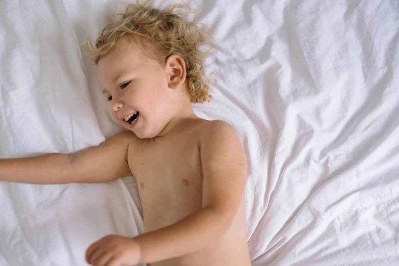 a small child laying on a bed laughing