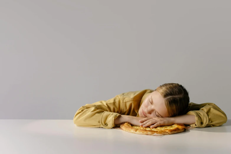 a child with his eyes closed laying on top of a table