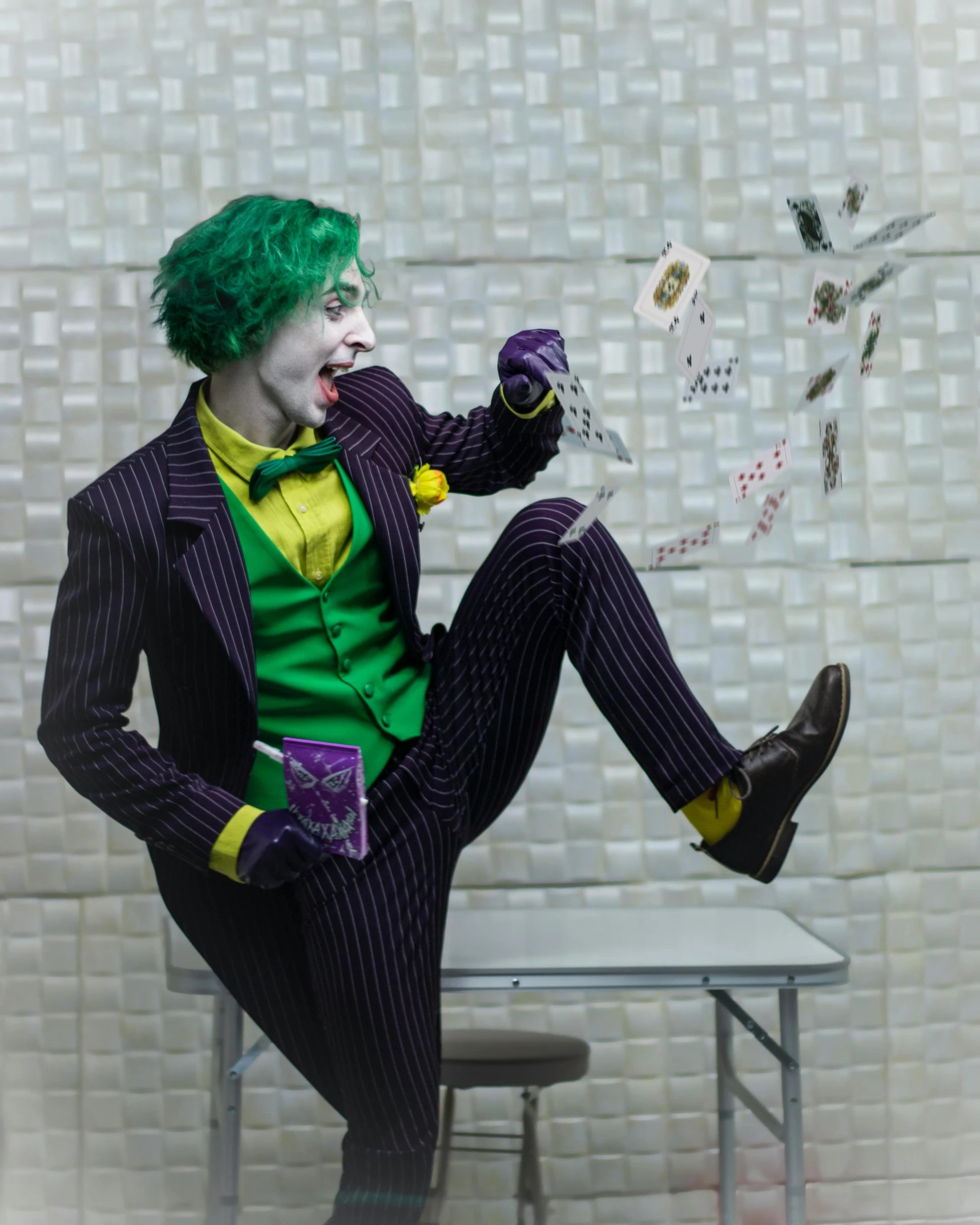 a person dressed in a joker outfit sitting on a chair