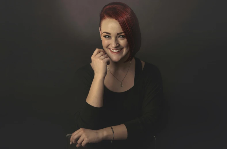 woman posing in studio with her chin resting on her hand