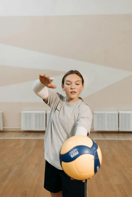 a boy is hitting a soccer ball with a glove