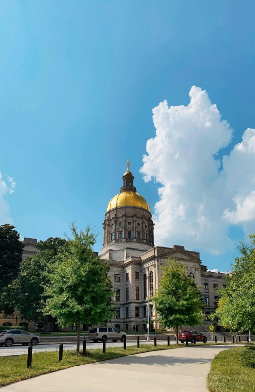 a church with a gold dome surrounded by green trees