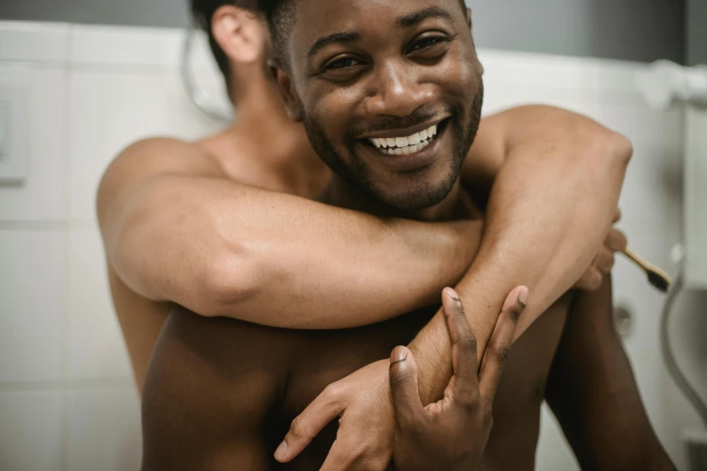 a couple of men hugging in a bathroom