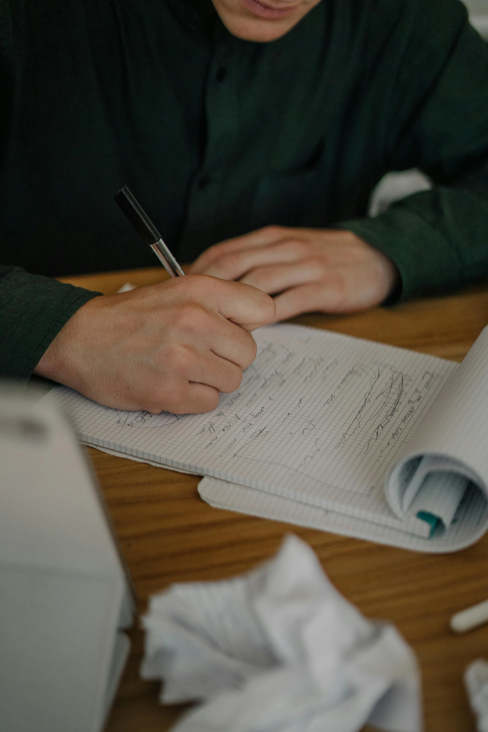 a person that is writing on paper on a desk