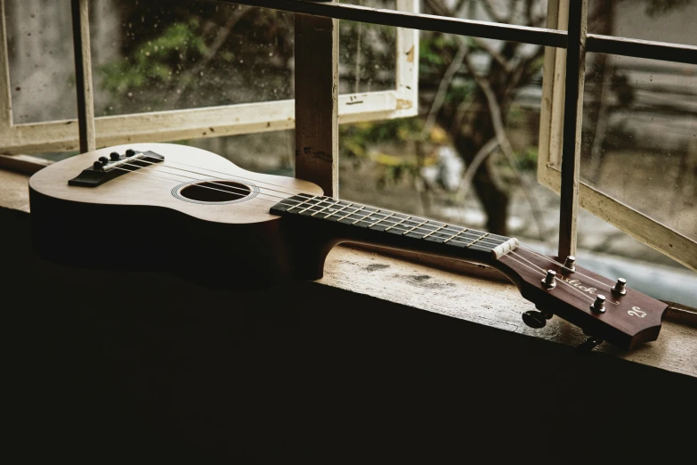 guitar and musical instrument on a window sill outside
