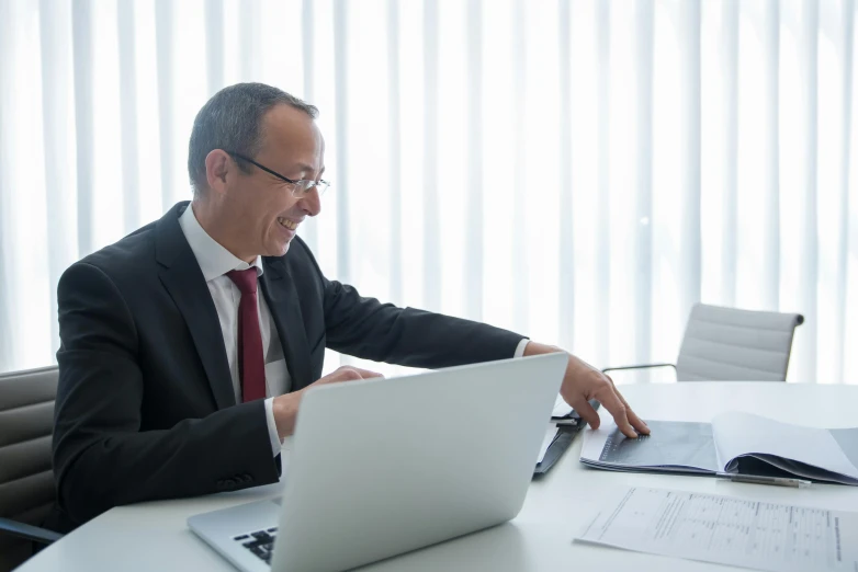 a man in suit working on laptop computer