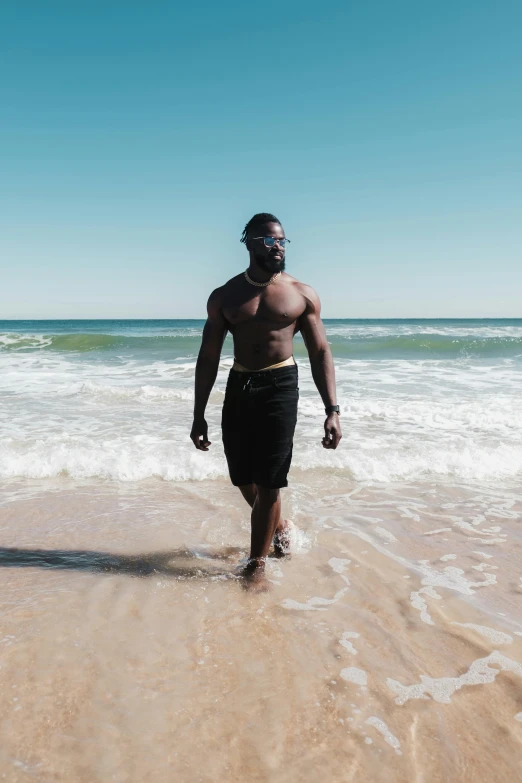 an african man is walking through the surf