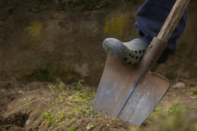 a person is shoveling soil in the garden