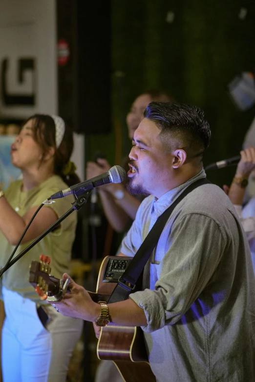 people watching a musician sing on stage