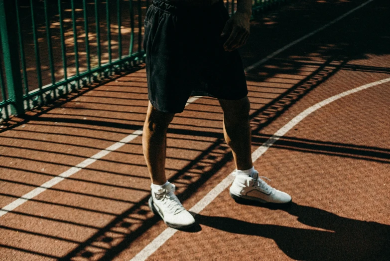 a tennis player's foot is visible as he walks across a court