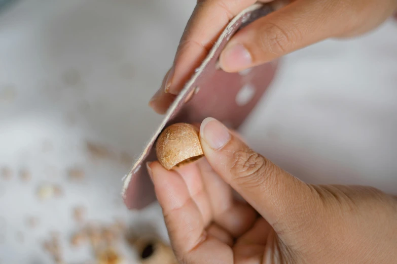 a small peanut on the fingers of someone holding it