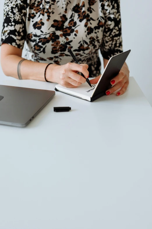 a woman at her desk writing with an electronic