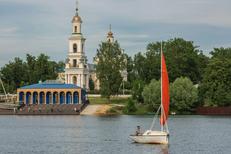 sailboat on the river in front of church with a gazebo