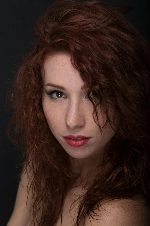 an attractive young woman with red hair posing for the camera