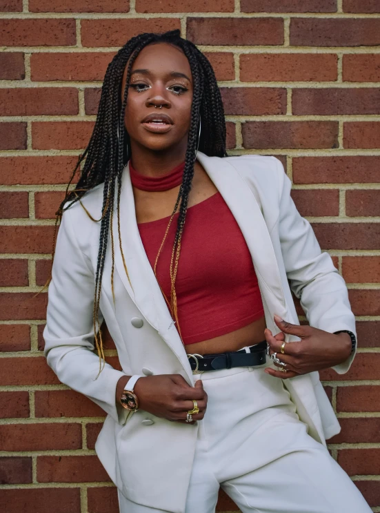 a beautiful black woman standing next to a brick wall