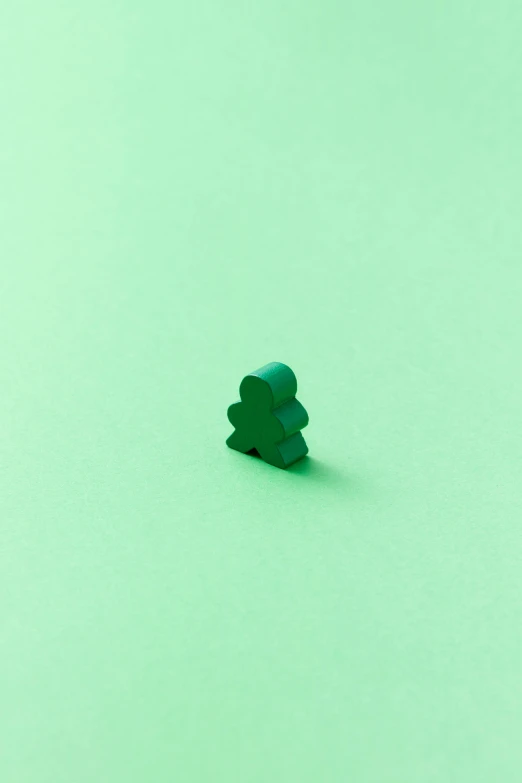 an image of tiny green tree toy on light green background