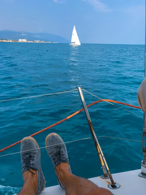 a person with their feet in the water on a boat