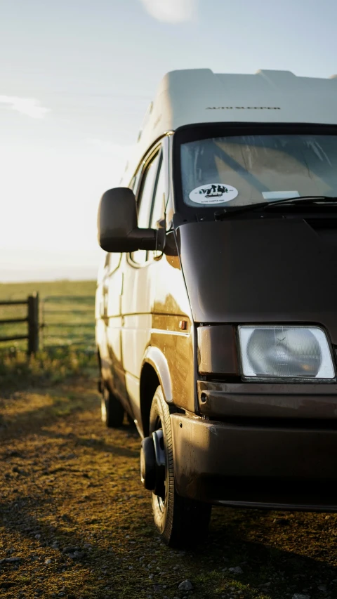 a van sits parked outside in the middle of a field