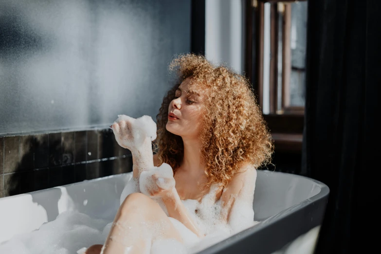 a woman taking a bubble bath in her bathroom