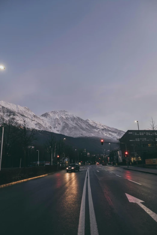 snow covered mountains loom over the city street