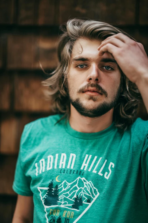 a young man wearing a green shirt is posing