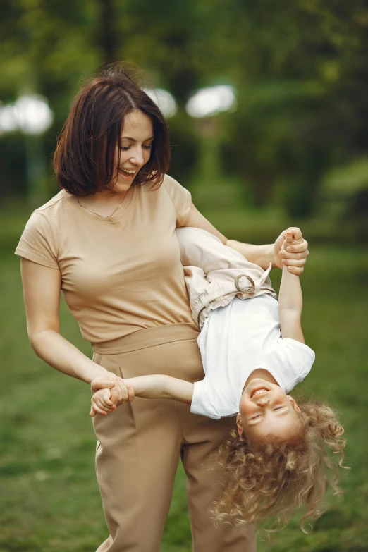 the woman and young child are playing in the field