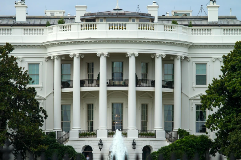 the white house sits among some trees and a pond