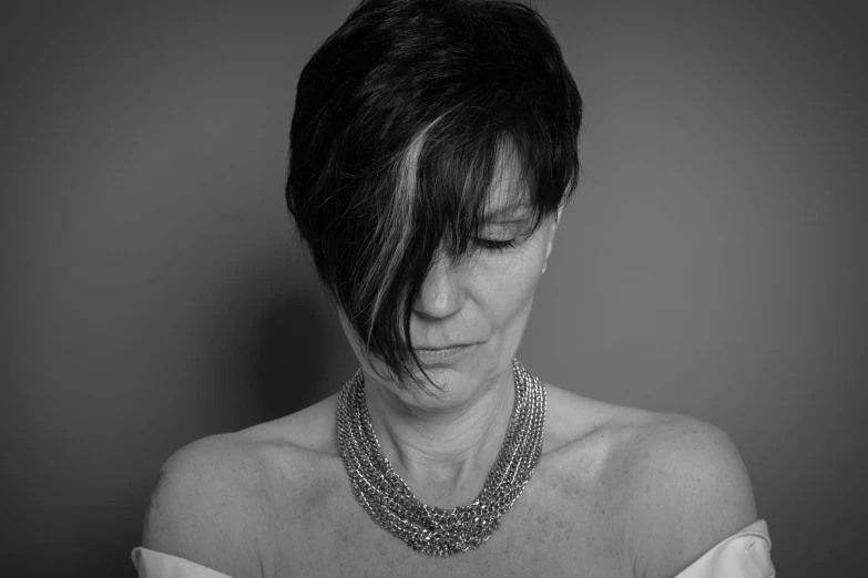 a black and white pograph of a woman with a necklace